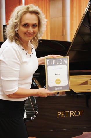 Mgr. Zuzana Ceralová Petrofová, president of the company PETROF, with the diploma of Superbrands