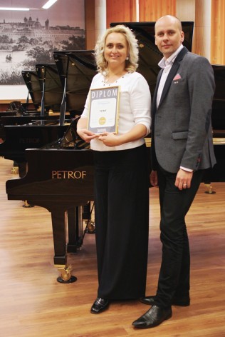 Mgr. Zuzana C. Petrofová receiving the Superbrands award for PETROF from the representative of Superbrands Czech Republic.